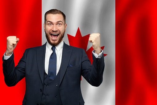 Canadian happy businessman on the background of flag of Canada Business, education, degree and citizenship concept