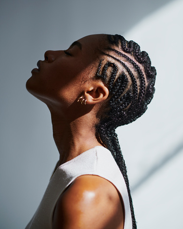 side profile shot of a beautiful black woman with cornrow braids, stock photo