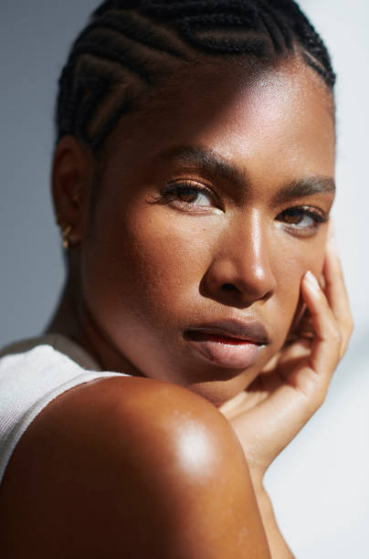 She has the smoothest skin, stock photo young black woman's smooth and beautiful skin as she looks over her shoulder into the camera. stock photo beauty product photography stock pictures, royalty-free photos & images