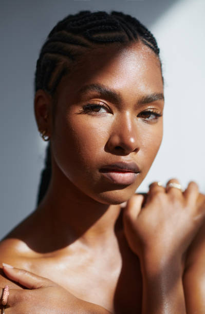 Beautiful brown eyed woman. stock photo Young black woman embracing herself while looking into the camera. stock photo black skin stock pictures, royalty-free photos & images