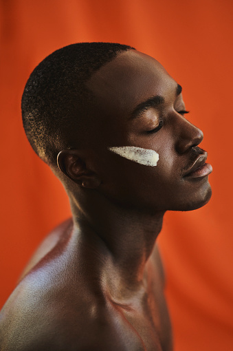 Dark skinned black male enjoying his skin care routine. stock photo