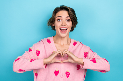 Portrait of overjoyed crazy cute girl wear stylish clothes two arm show you heart figure love feelings isolated on blue color background.