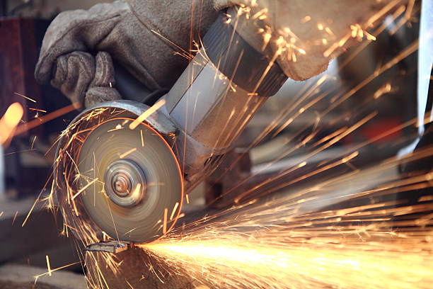 A person using a saw to cut metal stock photo