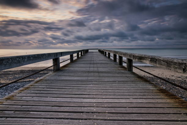 istock Wooden pier on cloudy sunset 1618322699