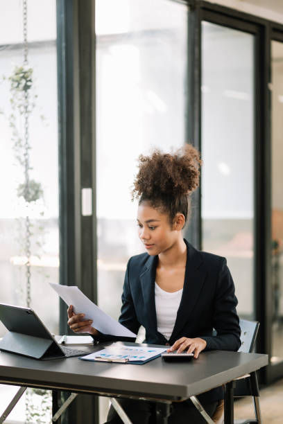 istock Young beautiful woman typing on tablet and laptop while sitting at the working  table office 1618325141