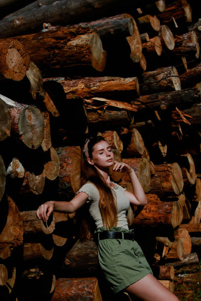 A Girl Resting Against a Heap of Chopped Timber