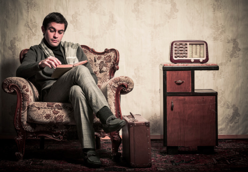 Elegant man listening the radio in old vintage room