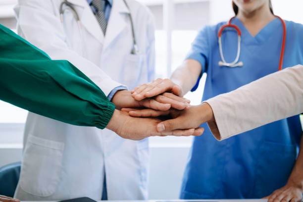 istock Team Doctors nurses union coordinate hands Teamwork Concept in hospital for success and trust in the team. 1618339433