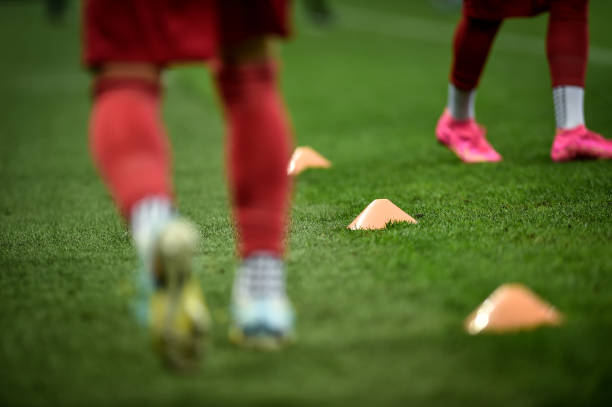istock Soccer players training with dribbling cones on turf 1618355011