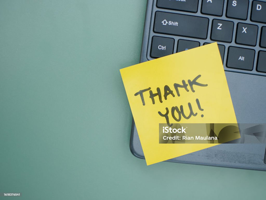 Top view of words thank you written on sticky note on laptop keyboard Thank You - Phrase Stock Photo