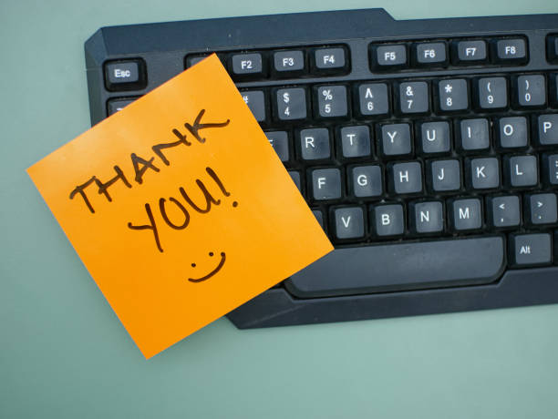 istock Top view of words thank you written on sticky note on keyboard 1618377068