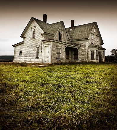 An old abandoned home sitting in a field.
