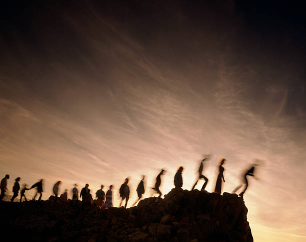 Blurred line of people on the edge of a cliff stock photo