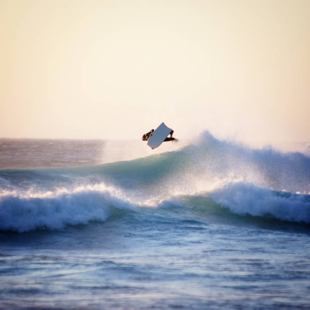 A huge wave with a bodyboarder flying on top Bodyboarder getting some air. Llundudno, Cape Town body board stock pictures, royalty-free photos & images