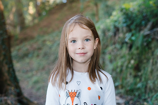 In Western Colorado Young Female Child Standing Outdoors Among Trees on a sunny Fall Day Looking into the Distance; Part of a Series (Shot with Canon 5DS 50.6mp photos professionally retouched - Lightroom / Photoshop - original size 5792 x 8688 downsampled as needed for clarity and select focus used for dramatic effect)