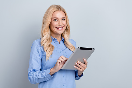 Photo of young lady wear formal shirt hold tablet browsing gadget secretary check information analysis isolated on grey color background.