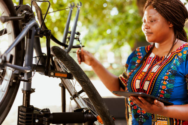 istock Woman using phone tablet to fix bicycle 1618422047