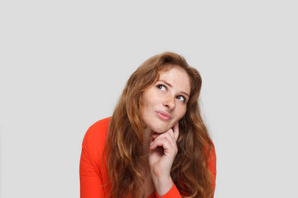 istock Thinking woman on white background, studio portrait 1618424261