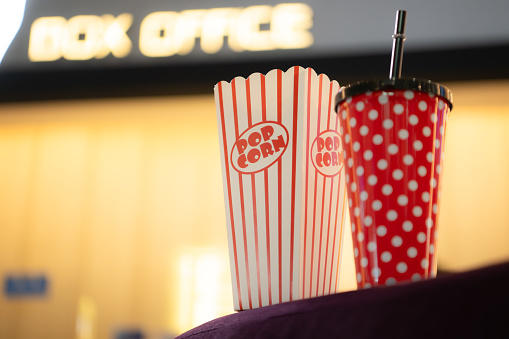 Popcorn and drinking glass a companion item of people for watching movies in the cinema.