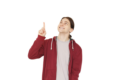 Happy young man pointing up at copy space isolated on white background