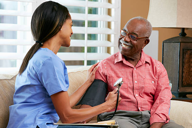 el personal de enfermería visita senior paciente de sexo masculino en su hogar - blood pressure gauge surveillance home interior house fotografías e imágenes de stock