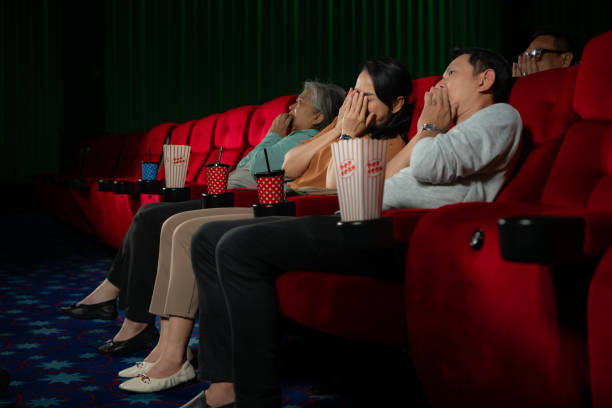 when watching scary ghost movies in theaters, moviegoers appear terrified. - audience surprise movie theater shock imagens e fotografias de stock