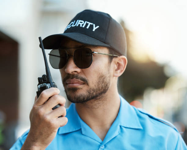 Security guard, safety officer or man with a walkie talkie outdoor on a city road for communication. Serious face of person with a radio on urban street to report crime, investigation or surveillance guardia de seguridad, oficial de seguridad u hombre con un walkie talkie al aire libre en una carretera de la ciudad para la comunicación. rostro grave de una persona con una radio en la calle urbana para denunciar delitos, investigación o vigilancia