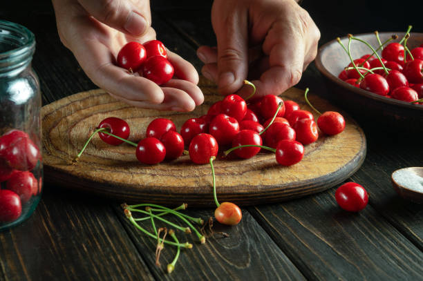 istock The cook prepares sweet jam from fresh cherries and sugar on the kitchen table. The process of canning cherry in a jar 1618464310