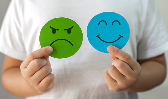 Smiley face written post its notes held by a paper clip on blue background. Horizontal composition with copy space. Feedback concept.