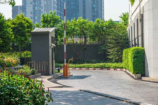 Outdoors vehicle car automatic security arm barrier gate at residential building entrance. Privacy, security system concept.