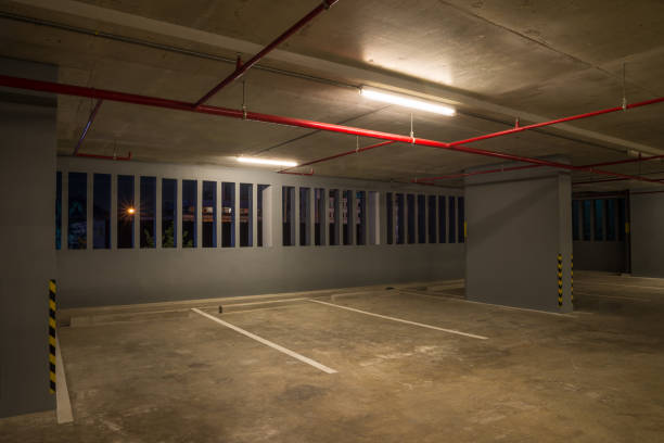 istock Parking garage interior in building at night with warm lighting. 1618479789