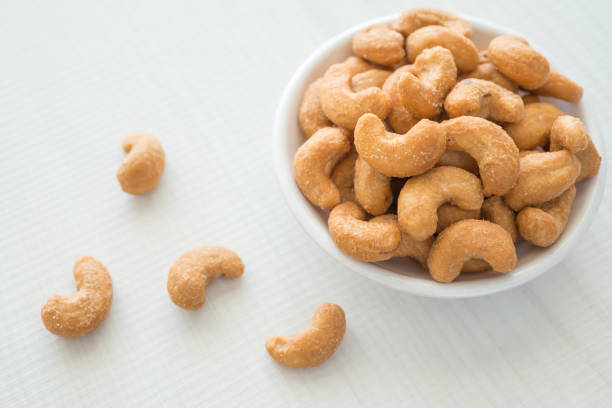 istock Salted cashew nuts in dessert bowl on white table 1618483541