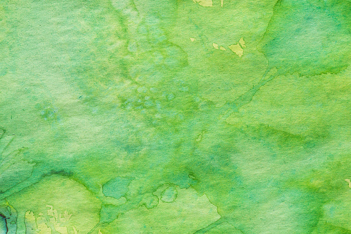 green watercolor painted background on paper texture