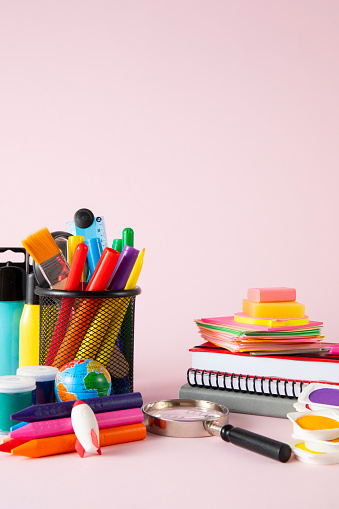 Back to school background with school supplies on pink background