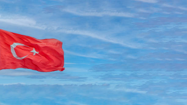 istock Turkish flag waving in a cloudy blue sky background with copy space. 1618502815