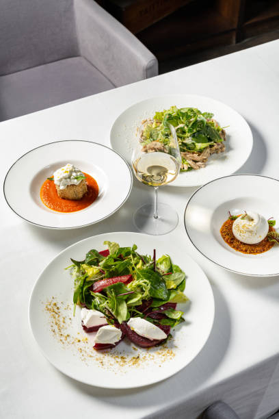 istock Mozzarella with vegetable stew and eggplant breaded with stracciatella cheese, chicken salad and glazed beetroot salad. Dishes lie in light ceramic plates on a light tablecloth. 1618503437