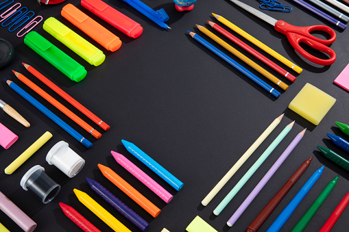 Back to school concept with school supplies knolling on black background
