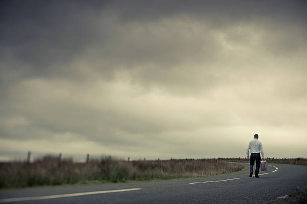 istock Lone Man with old suitcase on country road 161851489