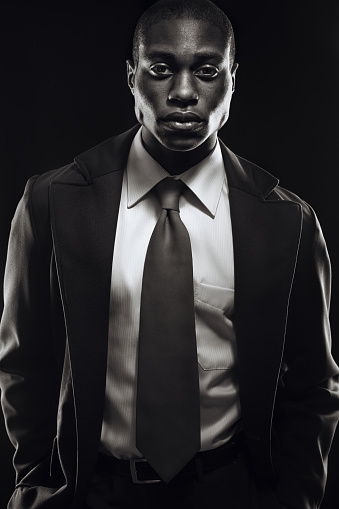 A low key shot of a young African American business man posing fashionably for a portrait.  Vertical black and white studio shot.\n[url=file_closeup?id=15304190][img]/file_thumbview/15304190/1[/img][/url] [url=file_closeup?id=16161594][img]/file_thumbview/16161594/1[/img][/url] [url=file_closeup?id=14791040][img]/file_thumbview/14791040/1[/img][/url] [url=file_closeup?id=14674467][img]/file_thumbview/14674467/1[/img][/url] [url=file_closeup?id=14984631][img]/file_thumbview/14984631/1[/img][/url]