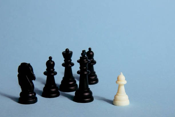 istock One chess piece against black chess pieces on a blue background with contrasting shadows 1618531921