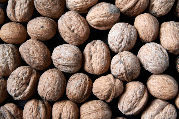 istock walnut on a black wooden background still life, walnut 1618557849