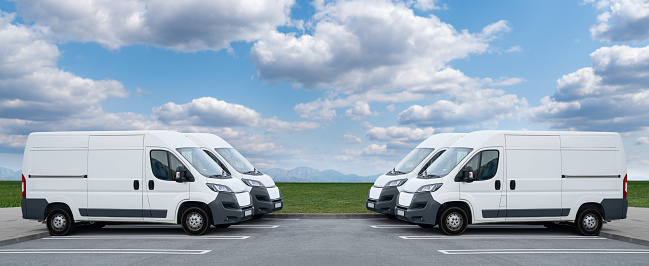 Delivery vans are parked in rows. Commercial fleet.