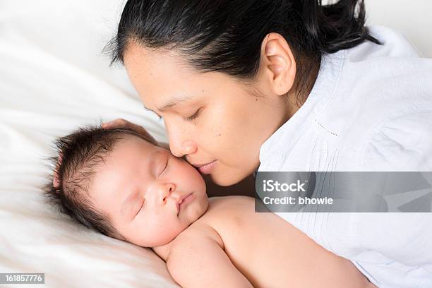 Asian Mother With Newborn Baby Boy On White Sheets Stock Photo - Download Image Now - Newborn, Kissing, Mother