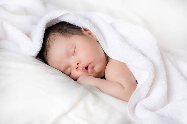 bebê recém-nascido dormir na cama branca após o banho - baby lying down sleeping asian ethnicity imagens e fotografias de stock