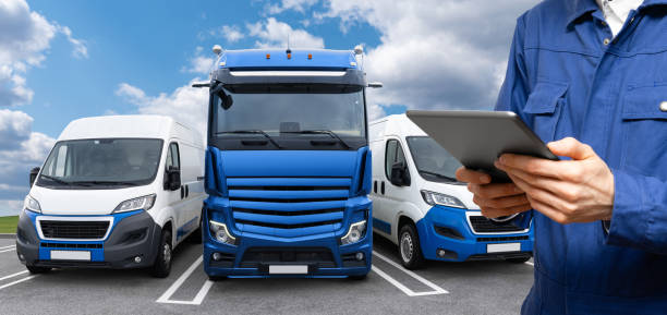 istock Manager with a digital tablet next to truck and vans. 1618581546