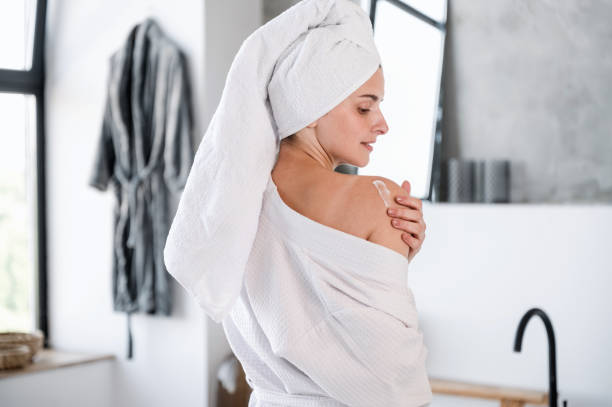istock Woman applying moisturizer cream on shoulder skin after shower 1618587372