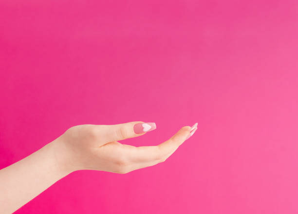 istock female hands with beautiful long nails with  manicure with  heart pattern on pink background 1618594874