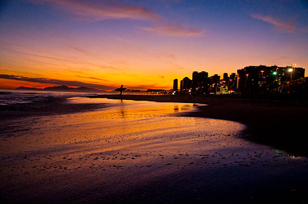 Surfer silhouette at nightfall in Barra da Tijuca beach