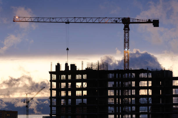 istock Tower crane, workers work at construction site. Process of building new houses 1618624557