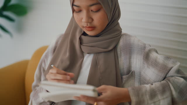 Focused Muslim Women students studying online courses at home.